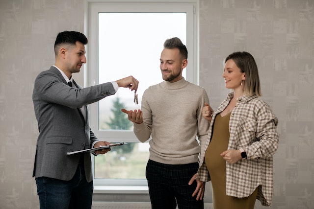 A real estate agent handing keys to a man