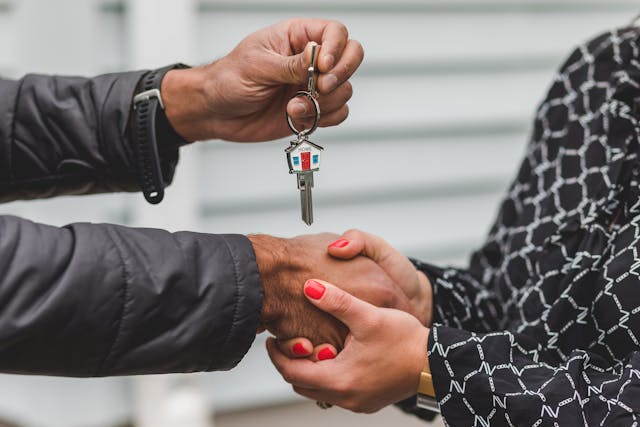 Person shaking hands with real estate agent after buying a new home