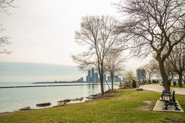 view of Detroit skyline from a riverside park symbolizing reasons why you shouldn’t skip Detroit if you are looking to invest in real estate