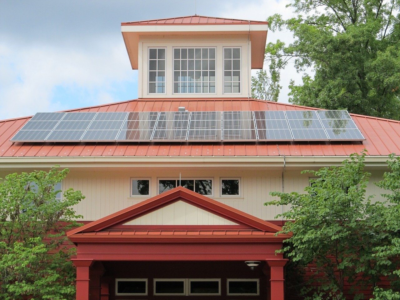 Solar panels on a red and white building.