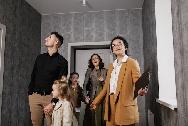 A family touring a house at an open house with a selling agent